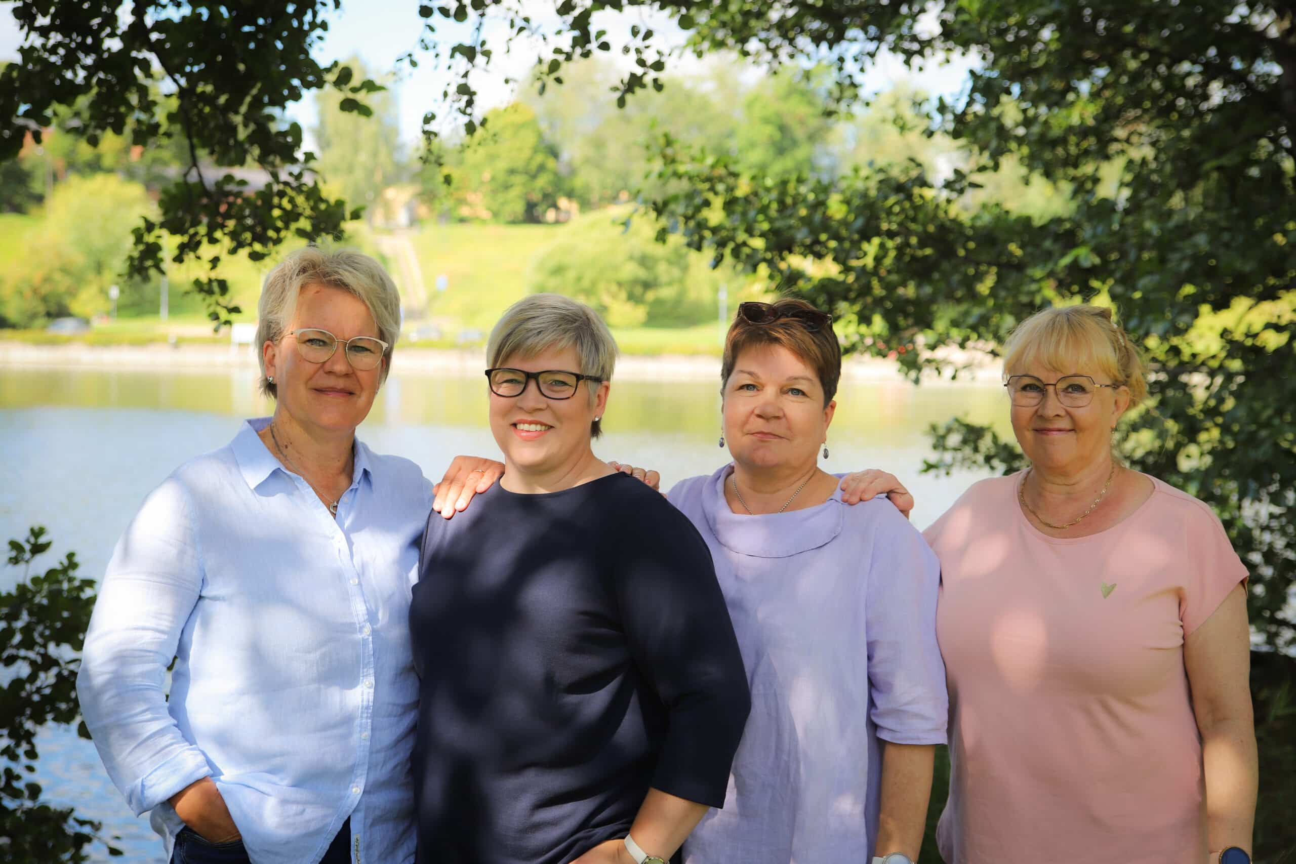 Saimaan Syöpäyhdistyksen sairaanhoitajat, taustalla järvi ja puita.