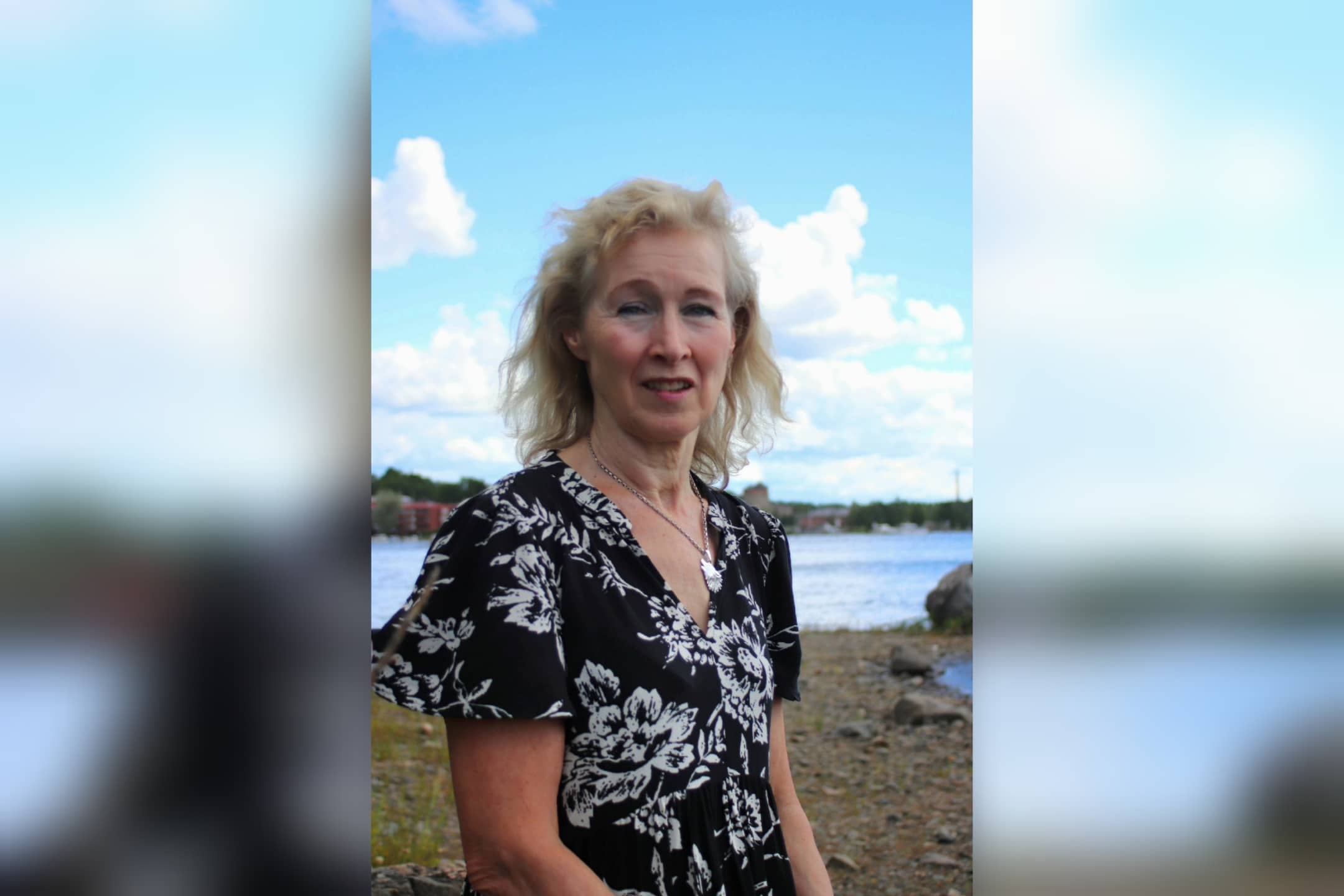 Kokemustoimija Johanna istuu ulkona, taustalla Saimaa.
